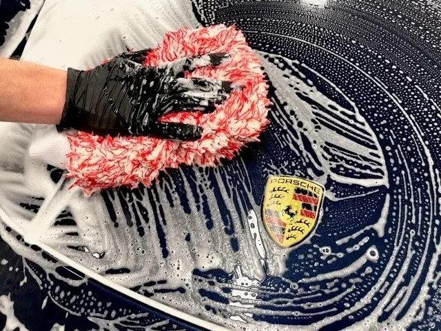 Lavage à la main d'une Porsche bleu nuit, detailing haut de gamme à Saint-Étienne